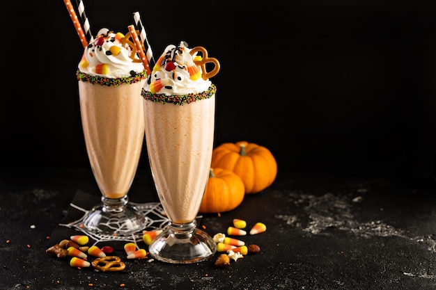 Halloween pumpkin milkshake decorated with candy