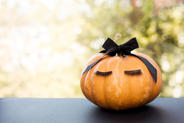 Photo halloween pumpkin with false eye lashes and bow beauty autumn