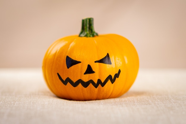 A Halloween pumpkin with a painted black face.