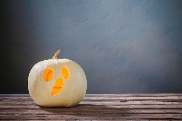 Halloween pumpkin on wooden table on dark blue background