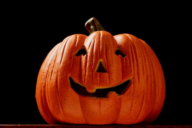 Halloween Pumpkin on wooden table in front of spooky dark