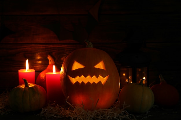 Halloween pumpkins and candles on dark wooden table, copy space