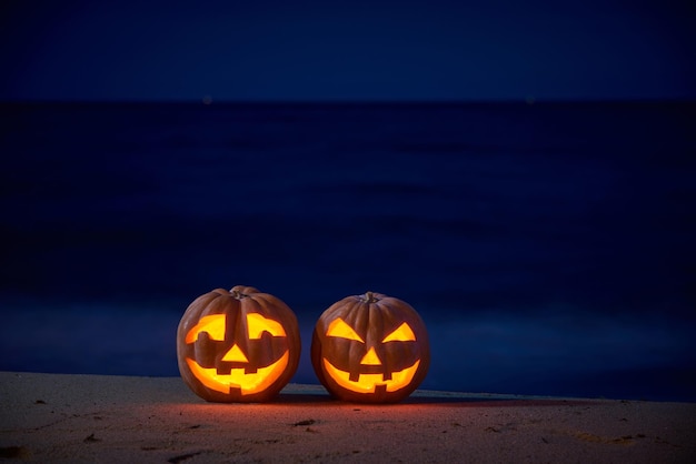 Halloween pumpkins jack p lantern on the sea beach at night in the bright moonlight