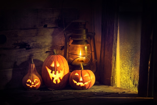 Halloween pumpkins and lantern in an old house by the window where the moonlight shines.