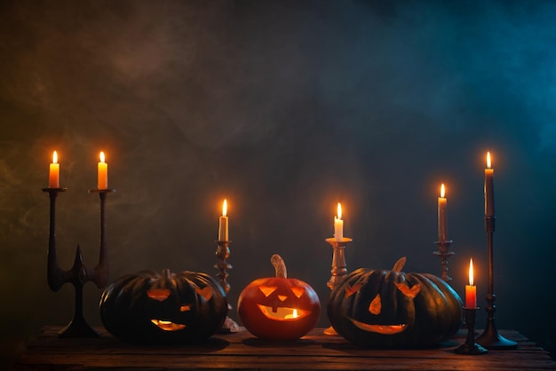 Halloween pumpkins with burning candles on dark background