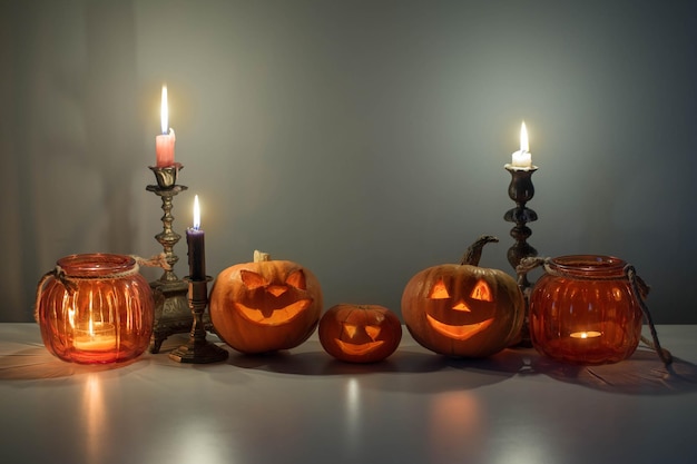 halloween pumpkins with burning candles on white table