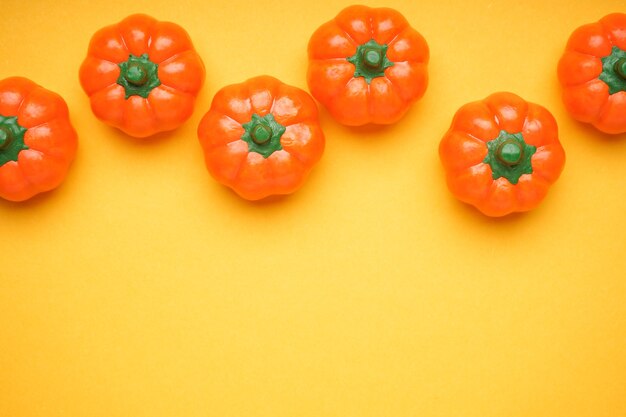 Halloween pumpkins on a yellow background, space for text, flat lay.