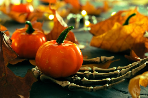 Halloween skeleton hand with decorative pumpkins