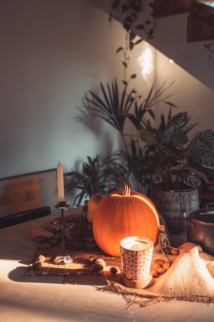 Halloween spooky pumpkin face in a table with decoration Skeleton candles nuts