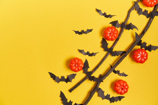 Halloween surface, orange decorative plastic pumpkin black paper bat dry branch stick yellow cardboard Thanksgiving greeting card pattern