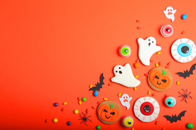 Halloween sweets on colored background close up top view with place for text