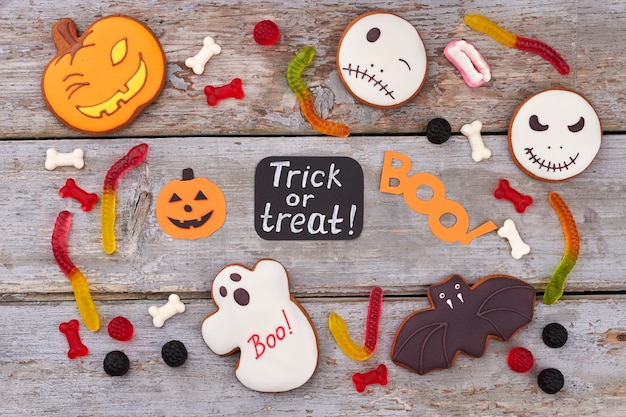 Photo halloween sweets on wooden background halloween concept with cookies and candies trick or treat