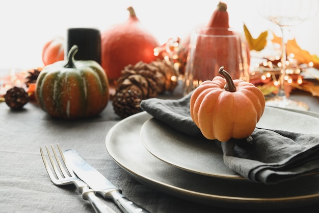 Halloween and thanksgiving day dinner decorated fallen leaves pumpkins spices grey plate