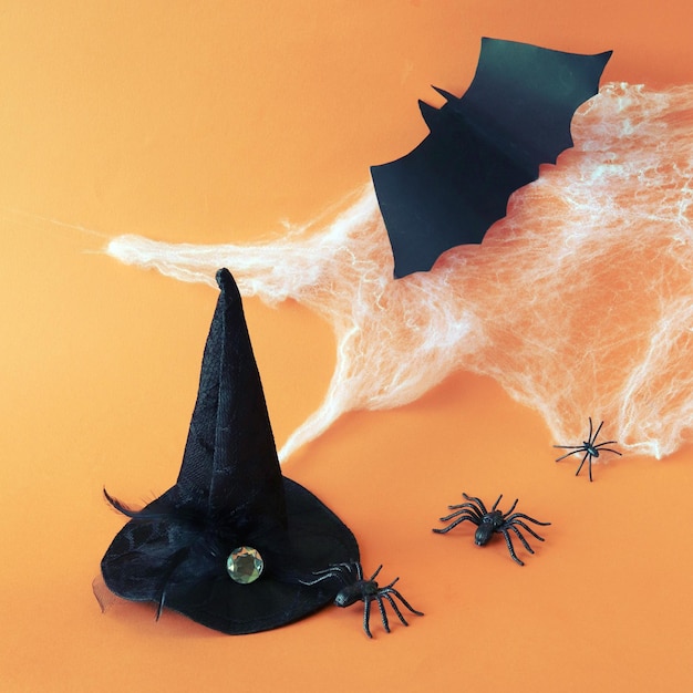 Halloween witch hat spiders decorations for the holiday against the background of a cobweb