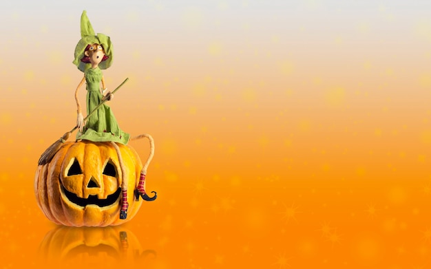 Halloween Witch sit on carved Pumpkin