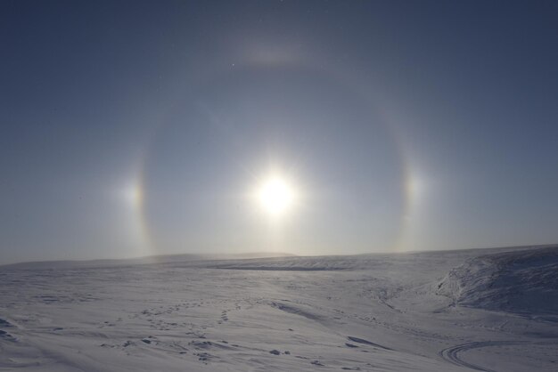 A halo of the sun is being halod on a snowy surface.