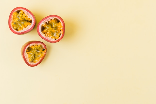 Halved passion fruits on beige background