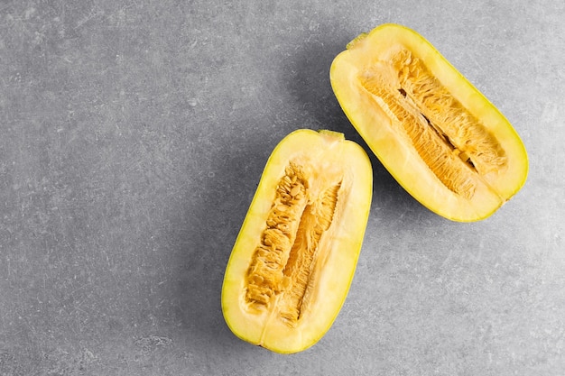 Halves of fresh spaghetti squash on grey background