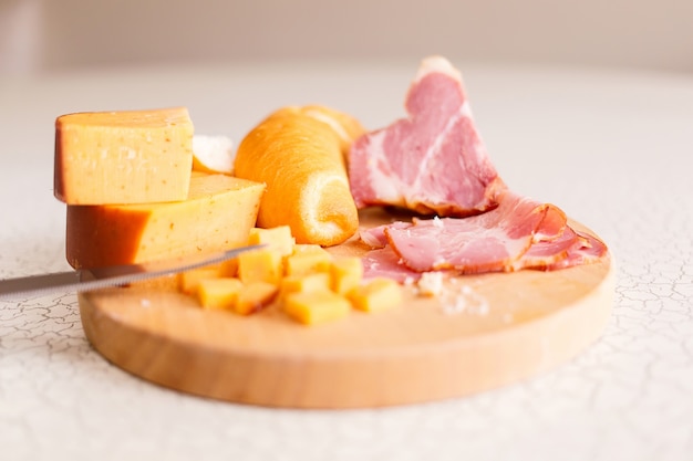 Ham, cheese and bread on a wooden cutting board