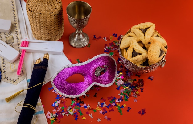 Hamans ears cookies for Purim Jewish holiday celebration with noisemaker and mask carnival kosher wine