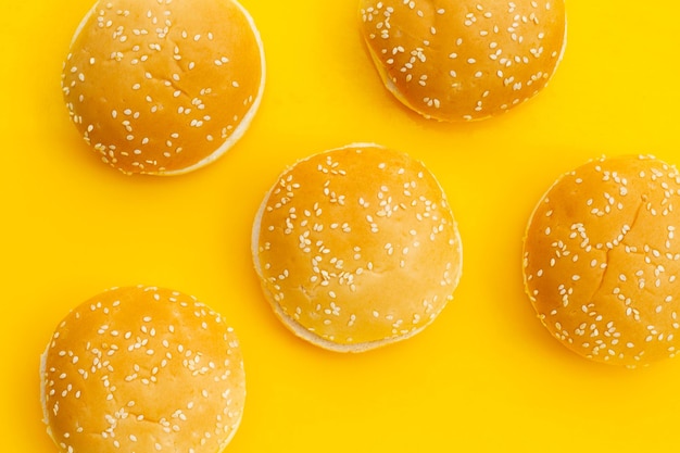 Hamburger buns with sesame on yellow background