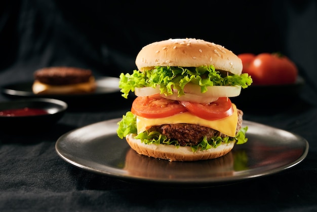 Hamburger with beef meat burger and fresh vegetables on dark background Tasty fast food