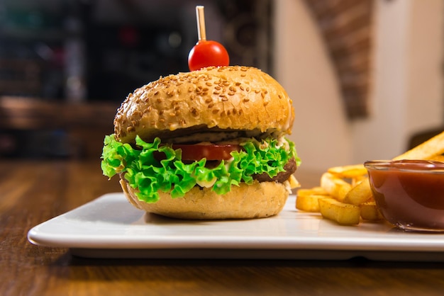 Hamburger with French fries on a wooden table