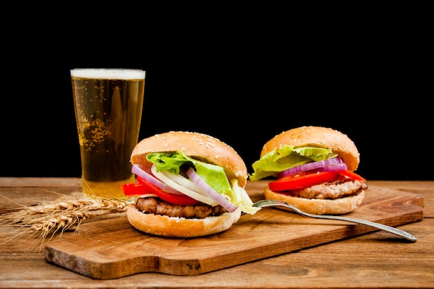 hamburger with mug of beer on wooden table