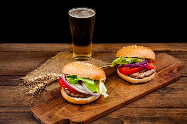 hamburger with mug of beer on wooden table