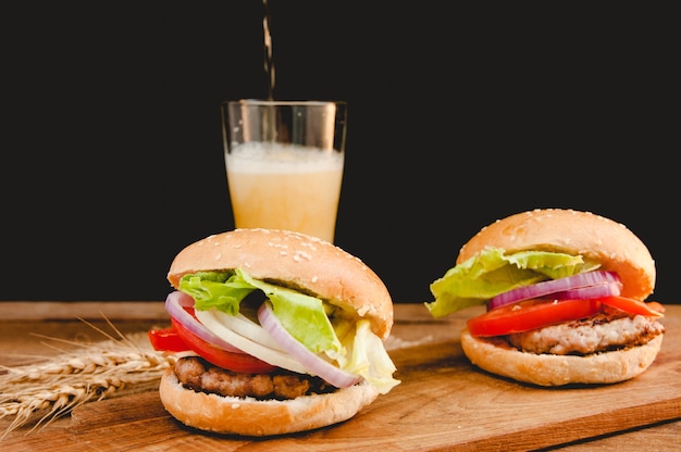 hamburger with mug of beer on wooden table