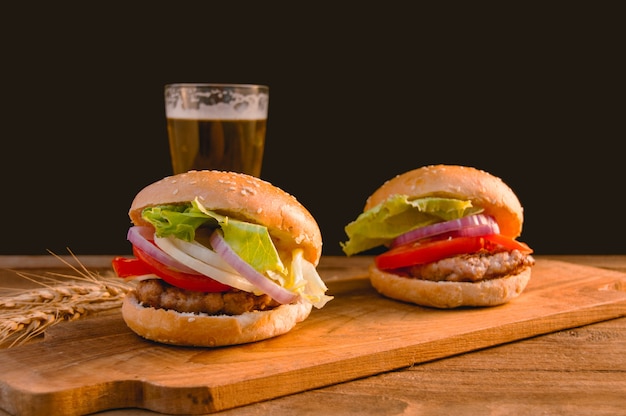 hamburger with mug of beer on wooden table