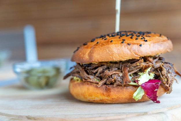 hamburger with shredded beef on a wooden board