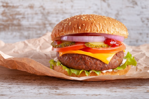 Hamburger with wrapping paper on wood table