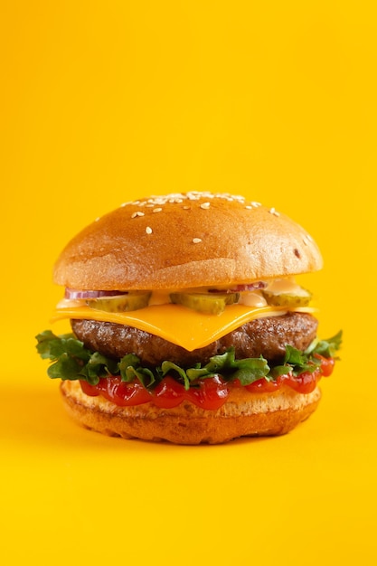 Hamburger on a yellow background. Fast food, junk food concept