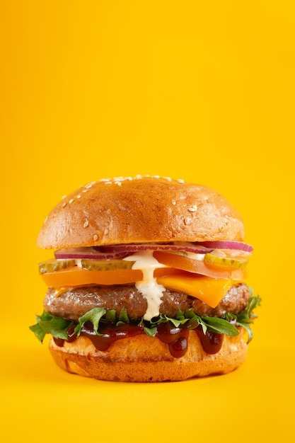 Hamburger on a yellow background. Fast food, junk food concept