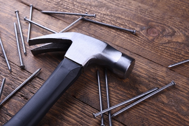 Hammer iron and nails on wooden table