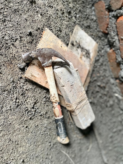 Photo a hammer is on a wall with a piece of wood on it.