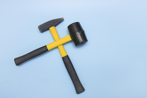 Hammer and mallet on a light blue background crosswise