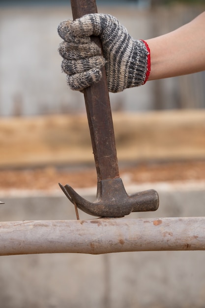 hammer pulling a nail out of wood