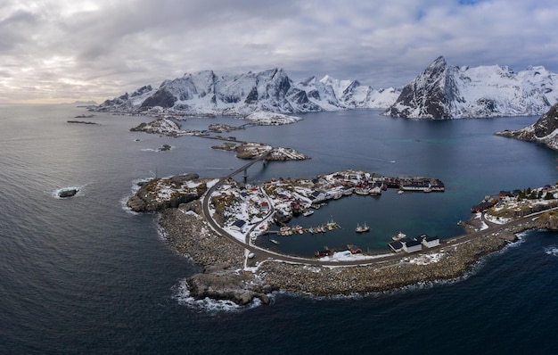 Hamnoy Village and Mountains in Winter. Norwegian Sea and Stormy Sky. Moskenes, Lofoten Islands, Norway. Aerial View.