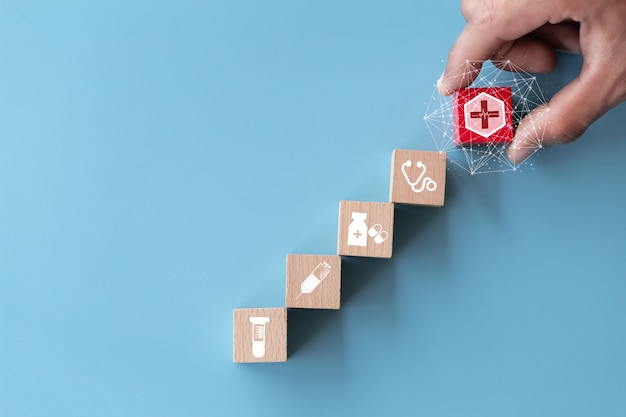 Hand arranging wood block stacking with icon healthcare medical