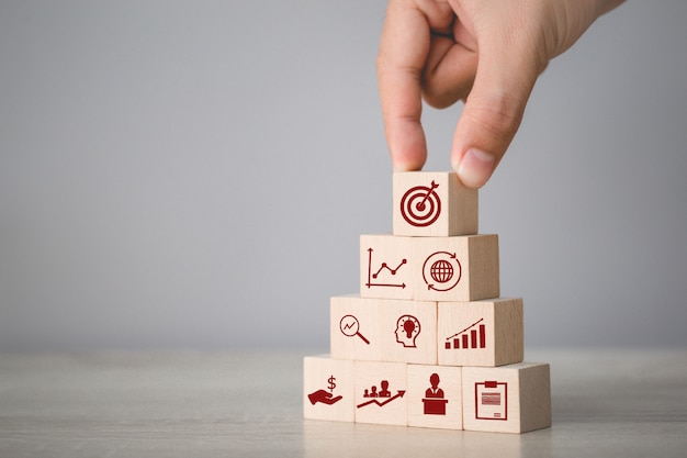 Hand arranging wood block stacking with icons