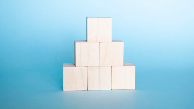 Hand arranging wood cube stacking as step stair. Business concept