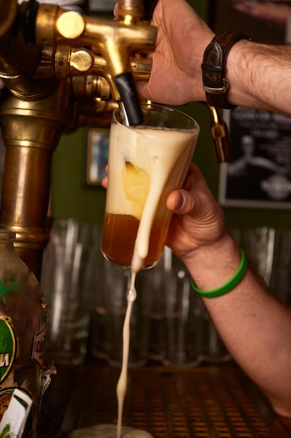 Hand bartender pouring large lager beer Light cold filtered beer in glass beaker