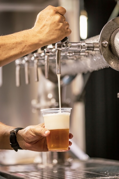 Hand of bartender pouring a pilsen chopp in tap