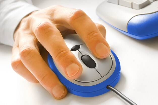 Hand and blue computer mouse with keyboard