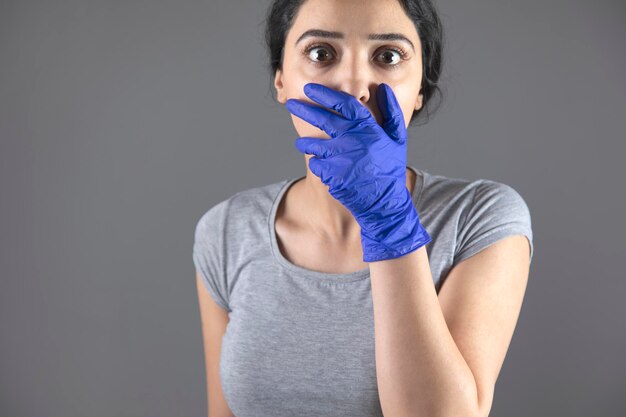 Hand blue glove and hand in mouth