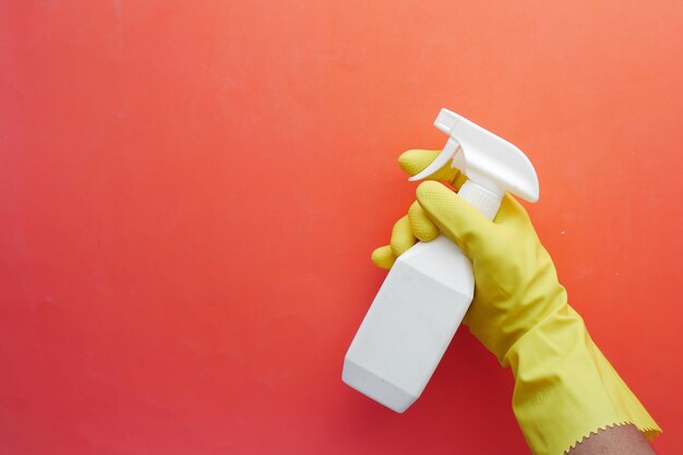 Hand in blue rubber gloves holding spray bottle with copy space