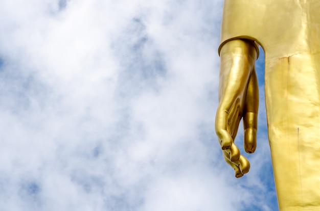 Hand of Buddha statue on blue sky