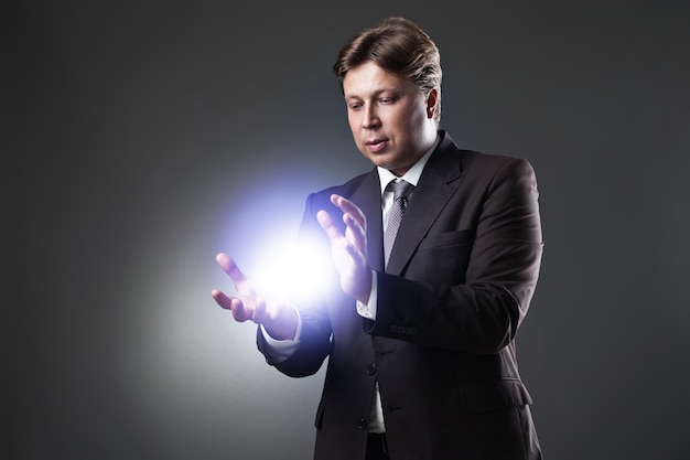 Hand of Business Man Hold light on dark background